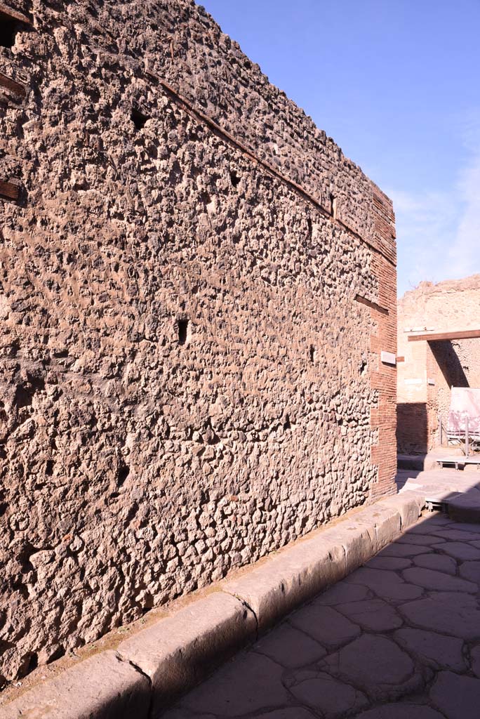 Vicolo del Citarista, west side, Pompeii. October 2019. 
Looking north along lower side wall of I.4.27, and pavement at junction with Via dell’Abbondanza, on right.
Foto Tobias Busen, ERC Grant 681269 DÉCOR.
