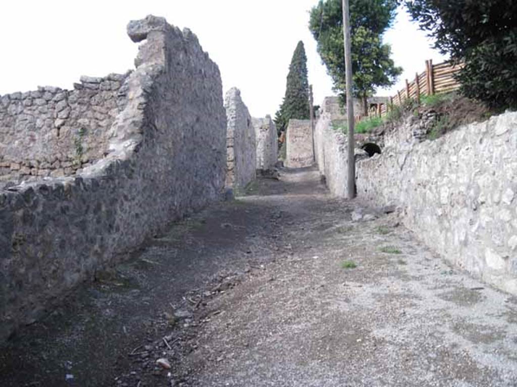 Vicolo del Citarista between I.22 and I.19 Pompeii. September 2010. Looking north, note arch by pole. Photo courtesy of Drew Baker.
