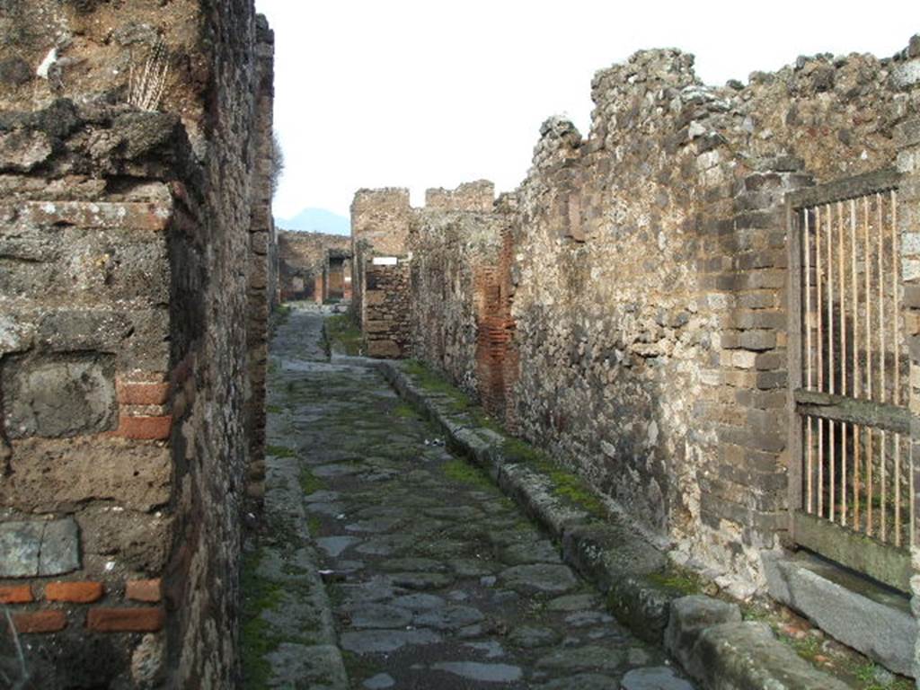 Vicolo della Maschera, east side,  between VII.13 and VII.14. December 2004.  Looking north to junction with Vicolo degli Scheletri. 

