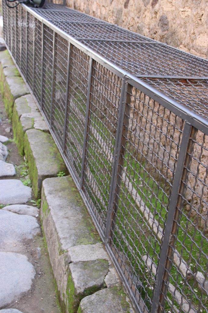 Vicolo di Mercurio, Pompeii. October 2023. 
Looking east along detail of edge of pavement on south side of roadway. Photo courtesy of Klaus Heese.
