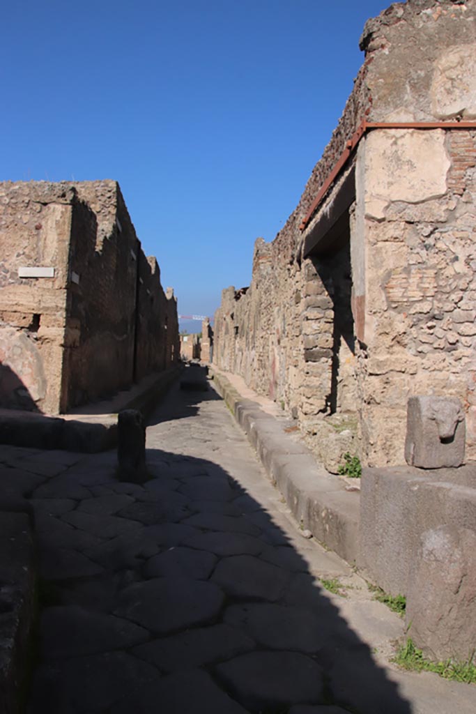 Vicolo di Tesmo between IX.1 and IX.7. Pompeii. October 2022. 
Looking north from IX.7.17, fountain on right. Photo courtesy of Klaus Heese. 
