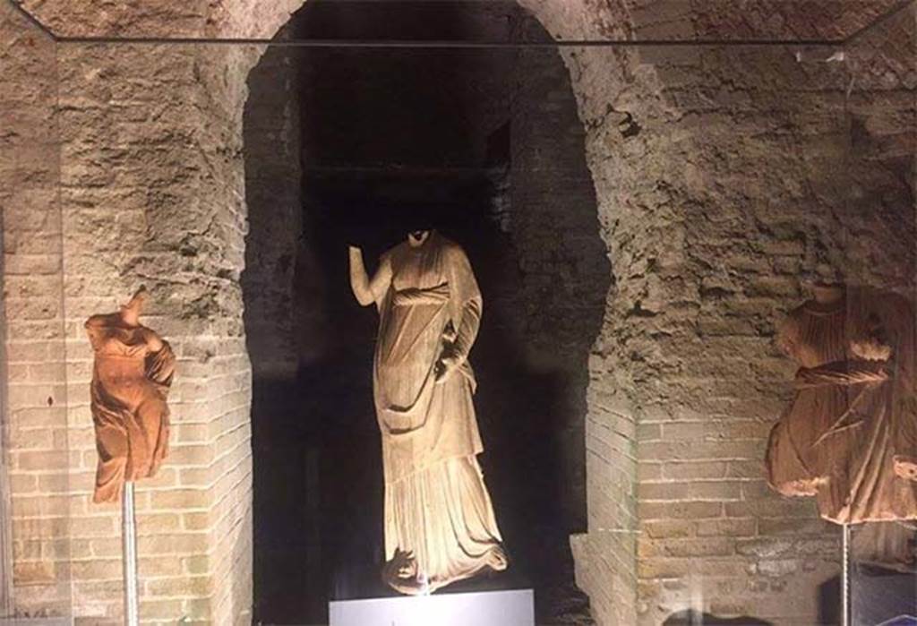 Santuario extraurbano del Fondo Iozzino. Three statues found upturned in the lapilli between the aediculae of the temple in 1960.
On the left is a statue of Aphrodite or Artemis-Hecate.
The other two statues may be identified with Demeter or Ceres. 
On show in the Villa Imperiale VIII.1.a, April 2016. 
