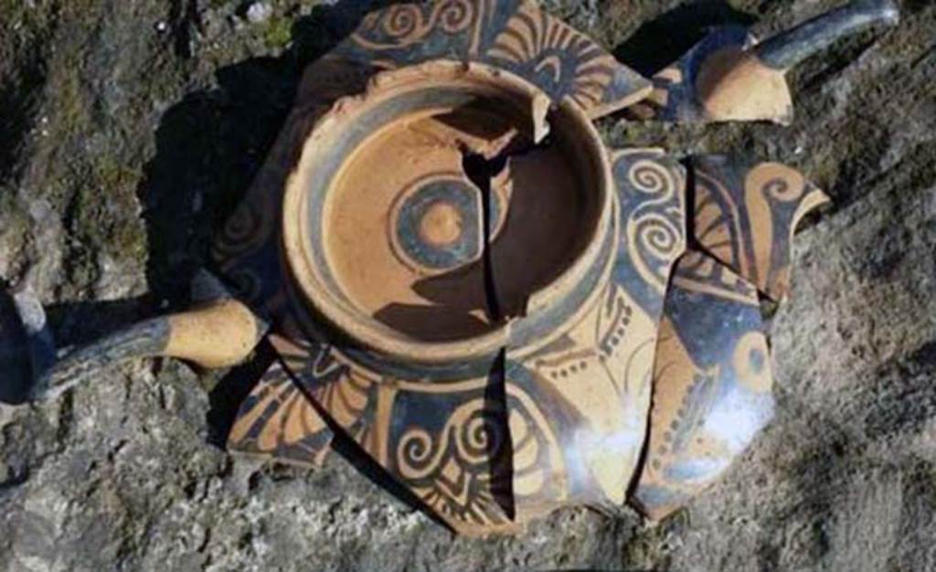 Santuario extraurbano del Fondo Iozzino. 2014. Decorated pottery with two horn style handles.
According to the PAP website, the most striking aspect of the finds dated to the Archaic Age is the sheer quantity of bucchero pottery with engraved inscriptions in the Etruscan language, which represents the largest corpus of Etruscan inscriptions yet found in a single context in Southern Italy. The bucchero pottery was employed in sacrifices which saw offerings of red or white wine, or herbal infusions, to the gods. 
The inscriptions were made on the basin and on the feet of the bowls and banquet vases, which after usage were deposited upside down on the ground.
These inscriptions reveal the names of those who made the offerings - Etruscans who also came from Tuscany, and of the deities to whom the sanctuary was dedicated - the god ‘apa’ or ‘father’ - perhaps Jupiter Meilichios. 

L’aspetto più eclatante dei ritrovamenti riferibili all’età arcaica è costituito dalla notevole quantità di vasellame in bucchero con iscrizioni graffite in lingua etrusca che rappresenta il più grande corpus di iscrizioni etrusche fino ad ora rinvenuto in un unico contesto in Italia meridionale. Il vasellame in bucchero era utilizzato per sacrifici che prevedevano l’offerta alle divinità di vino rosso e bianco, o infusi d’erbe.
Le iscrizioni erano poste sulla vasca e sul piede di scodelle e di vasi da banchetto che, dopo l’uso, venivano deposti capovolti sul suolo. 
Queste iscrizioni rivelano i nomi degli offerenti, etruschi che provenivano anche dalla Toscana, e della divinità a cui era dedicato il santuario, il dio “apa” “padre”, forse Giove Meilichios.

Photograph © Parco Archeologico di Pompei.
