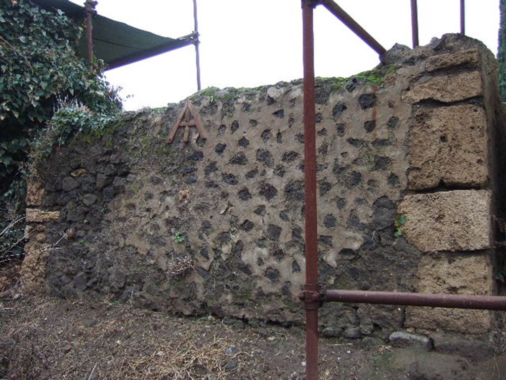 FPNC Pompeii. December 2005. South side of tomb. In the centre of the front of the tomb is a representation of a libella or builders level. This is made from fragments of tile built in to the wall.