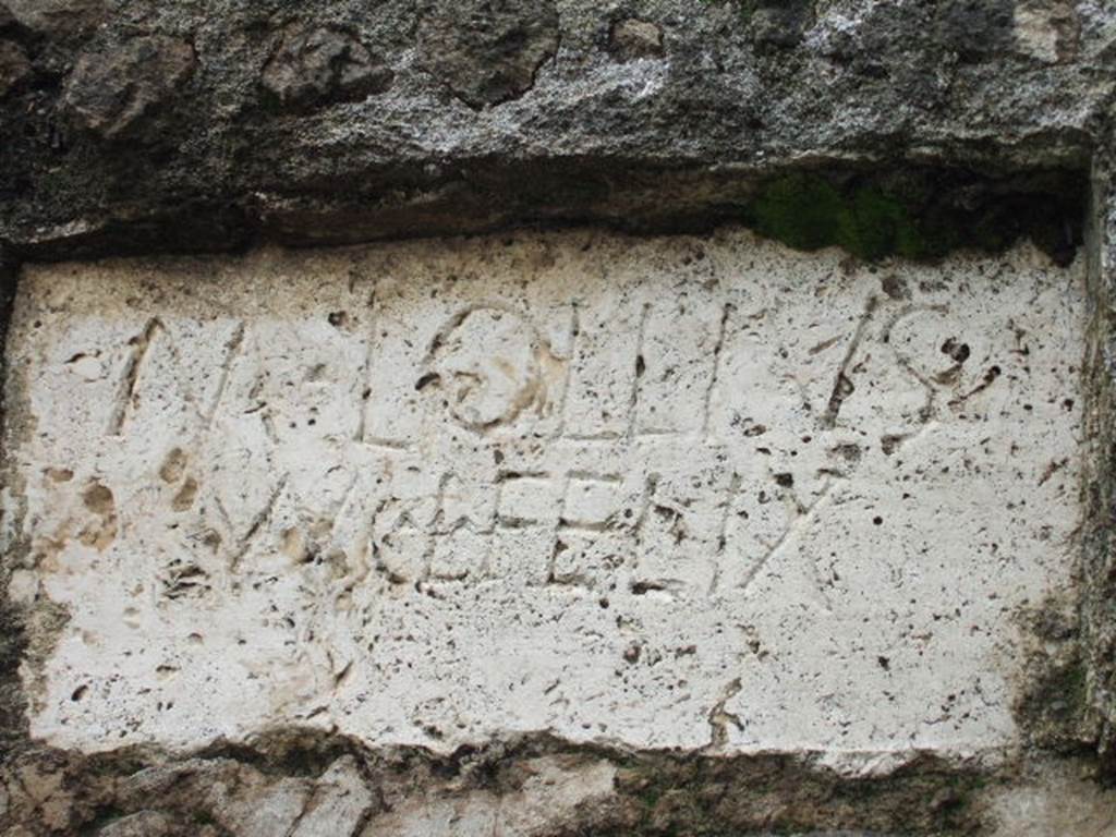 FPNI Pompeii. December 2005. Plaque on west end of south side with inscription:

According to D’Ambrosio and De Caro, this was possibly of non-local travertine and read

M  LOLLIVS  
M  L  FELIX

They expand this to

M(arcus)  Lollius  
M(arci)  l(ibertus), Felix

See D’Ambrosio A. and De Caro S., 1988. Römische Gräberstraßen. München: C.H.Beck. p. 214.