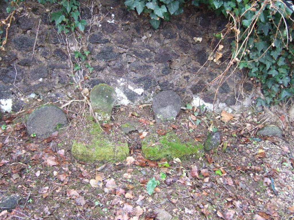 FPSC Pompeii. December 2005. Three uninscribed columellae at the south end of the tomb. The eastern columella, on the left, with the largest head, was for a male. The columella in the centre was also male. In front of it was a tufa tablet with a hole for the libation. The western columella, on the right, was female. In front of it was a tufa tablet with a hole for the libation. A fragment of a glass perfume bottle was found between the centre and western columellae.