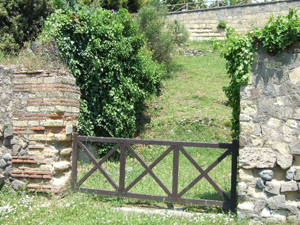 HGE24 Pompeii. May 2006. Looking north-east towards entrance doorway. According to Garcia y Garcia, on 18th September 1943 a bomb smashed the poor remains of the shops at HGE22, 23, 24 and the colonnade outside them. The damage was not recorded in the official report, but can be seen in a photo (fig.398 -Foto SAP neg 57-A) See Garcia y Garcia, L., 2006. Danni di guerra a Pompei. Rome: LErma di Bretschneider. (p.163).