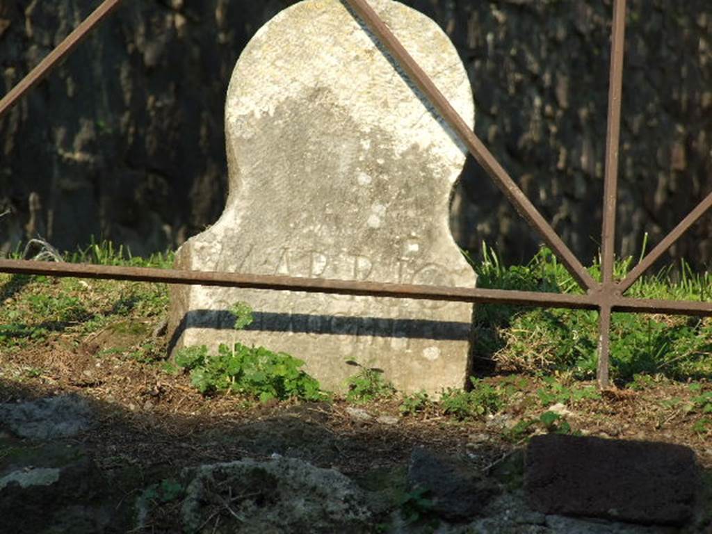 Pompeii. December 2006. Columella found in situ at front of HGE42. 
According to Kockel it is not mentioned in the excavation reports.
He presumes it to have been found in 1774 at the same times as the marble plaques.
See Kockel V., 1983. Die Grabbauten vor dem Herkulaner Tor in Pompeji. Mainz: von Zabern. (p. 181).
This columella has the inscription
M ARRIO 
PRIMOGENI

According to Epigraphik-Datenbank Clauss/Slaby (See www.manfredclauss.de) this reads

M(arco) Arrio
Primogeni        [CIL X 1045]