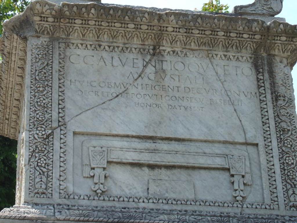 HGW20 Pompeii.  May 2006. North side of marble altar with inscription and bisellium.
The inscription reads:
C.  CALVENTIO  QVIETO
AVGVSTALI
HVIC OB  MVNIFICENT  DECVRIONVM
DECRETO  ET  POPVLI  CONSESV  BISELLII
HONOR  DATVS  EST

According to Epigraphik-Datenbank Clauss/Slaby (See www.manfredclauss.de) this reads

C(aio) Calventio Quieto
Augustali
huic ob munificent(iam) decurionum
decreto et populi conse(n)su bisellii
honor datus est      [CIL X 1026]

Mau translates this as:
To the memory of Gaius Calventius Quietus, member of the Brotherhood of Augustus.
On account of his generosity the honour of a seat of double width was conferred upon him by the vote of the city council and the approval of the people.
See Mau, A., 1907, translated by Kelsey, F. W., Pompeii: Its Life and Art. New York: Macmillan. (p. 421).