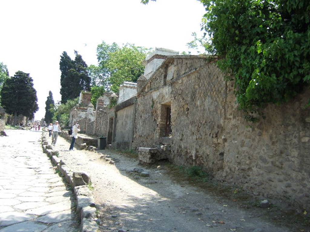 HGW24 Pompeii. May 2006. Looking south along Via dei Sepolcri. 
According to the plan by La Vega, nos 98 and 99 were found on this side of the roadway.
From PAH, addendum, p.133  
Relazione delle antichita, che si vanno ritrovando nella masseria del sig. D. Giovanni Milano parsonaro, che si era principiata al di 14 Febbraro 1771. (Report of Antiquities found.....)
N.98. A di 12 gennaio 1775. Si e trovata in una tavola di marmo larga pal. 2 on. 4  per pal. 1 on. 11 la seguente iscrizione:
CN VIBRIO Q F FAL SATURNINO CALLISTUS LIB
From PAH addendum, p.160 - 
14 Gennaio 1775  Altro sepolcro di Cn. Vibrio Saturnino; no. 98 pianta di La Vega.
28 Gennaio 1775  Il medesimo contiene un triclinio.

(Fontaine, South of villa faade, west side of roadway, (see HGW23).

From PAH, addendum, p.133  
Relazione delle antichita, che si vanno ritrovando nella masseria del sig. D. Giovanni Milano parsonaro, che si era principiata al di 14 Febbraro 1771. (Report of Antiquities found.....)
N.99. Nel mese di aprile 1790 per le acque cadute si e fatto un fosso nel sito contrassegnato, e nel muro vi erano i seguenti caratteri alti pal. 2 , e che di seguito dagli antichi erano stati imbiancati, e sono GABINIG.. Si e fatto riempire il fosso, e liscrizione resta ove si e veduta.

(Fontaine, North of 98, south of villa faade, west side of roadway, (right side of photo).
