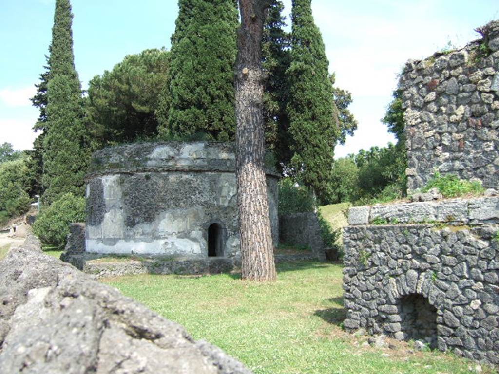 Pompeii Porta Nocera. Looking east towards 3ES on left, from near 1ES on right. May 2006. A columella was found to the north east of 1ES. This had the inscription 
HALO 
FILIO  P(ater).
This could not necessarily be attributed to either 1ES or 3ES.
See DAmbrosio, A. and De Caro, S., 1983. Un Impegno per Pompei: Fotopiano e documentazione della Necropoli di Porta Nocera. Milano: Touring Club Italiano.  (3ES).

