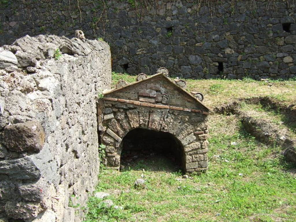 Pompeii Porta Nocera. Tomb 25aOS. May 2006. Tomb of Castricia Prisca. 
The tomb originally had painted cherubs, birds and garlands on the front.
A plaque on the tomb had the inscription
CASTRICIA G(aiae) LIB(ertae)
PRISCAE VIXIT ANNIS
XXV HIC SITA EST.
SAP inventory number 21003.

Inside at the centre of the back wall was a columella with the inscription
CASTRICIA G(aiae) 
L(iberta) PRISCA
VIX(it) ANN(is) XXV H(ic) S(ita) E(st).
