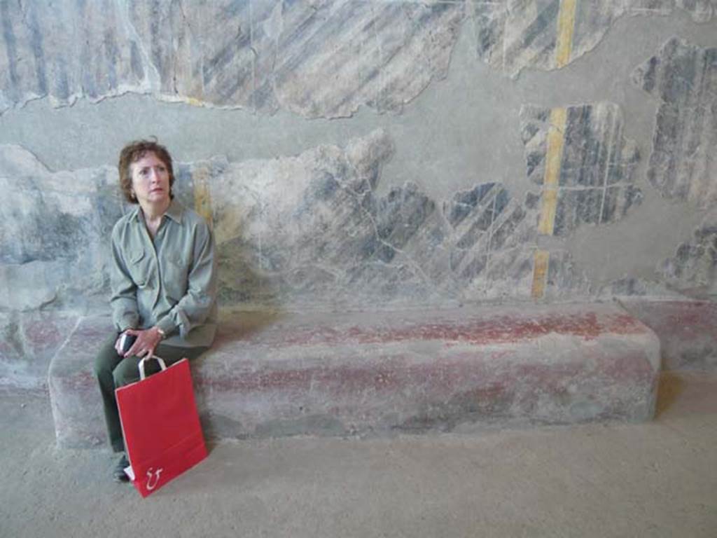 Oplontis, May 2011. Corridor 46, detail of bench near south wall, including a “sitting” tourist for scale.  Photo courtesy of Buzz Ferebee. 
