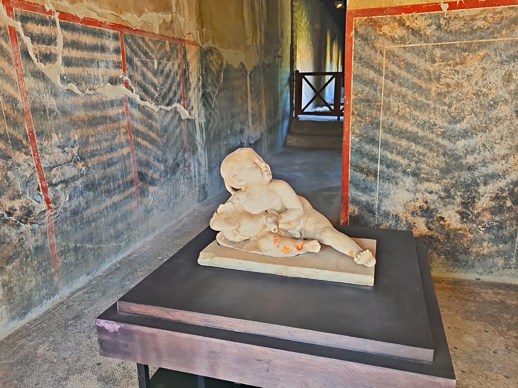 Oplontis Villa of Poppea, October 2023. Corridor 63, marble statue of young boy and goose. Photo courtesy of Giuseppe Ciaramella. 