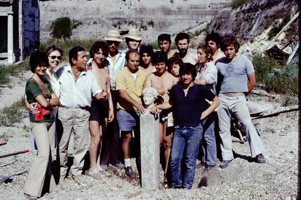 Oplontis, 1975. After the head had been photographed, our workers grouped themselves around it, for a photo with their most important find. Then the head was carried to the restorers for cleaning. Photo by Stanley A. Jashemski.   
Source: The Wilhelmina and Stanley A. Jashemski archive in the University of Maryland Library, Special Collections (See collection page) and made available under the Creative Commons Attribution-Non Commercial License v.4. See Licence and use details. J74f0906
