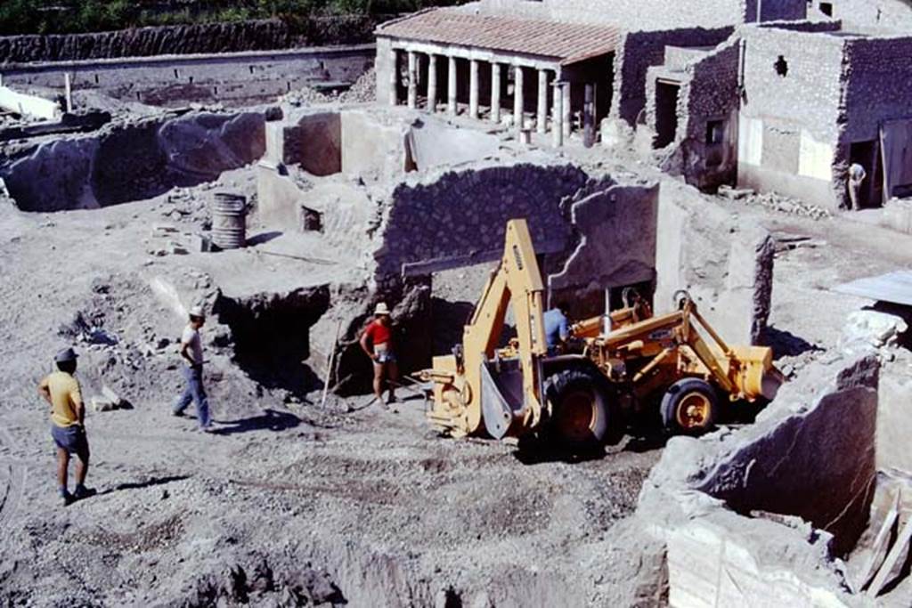 Oplontis, 1975. Looking south-west across room 69, with large yellow machinery. 
The south-east peristyle, area 59, can be seen at the centre top. Photo by Stanley A. Jashemski.   
Source: The Wilhelmina and Stanley A. Jashemski archive in the University of Maryland Library, Special Collections (See collection page) and made available under the Creative Commons Attribution-Non Commercial License v.4. See Licence and use details. J75f0023
