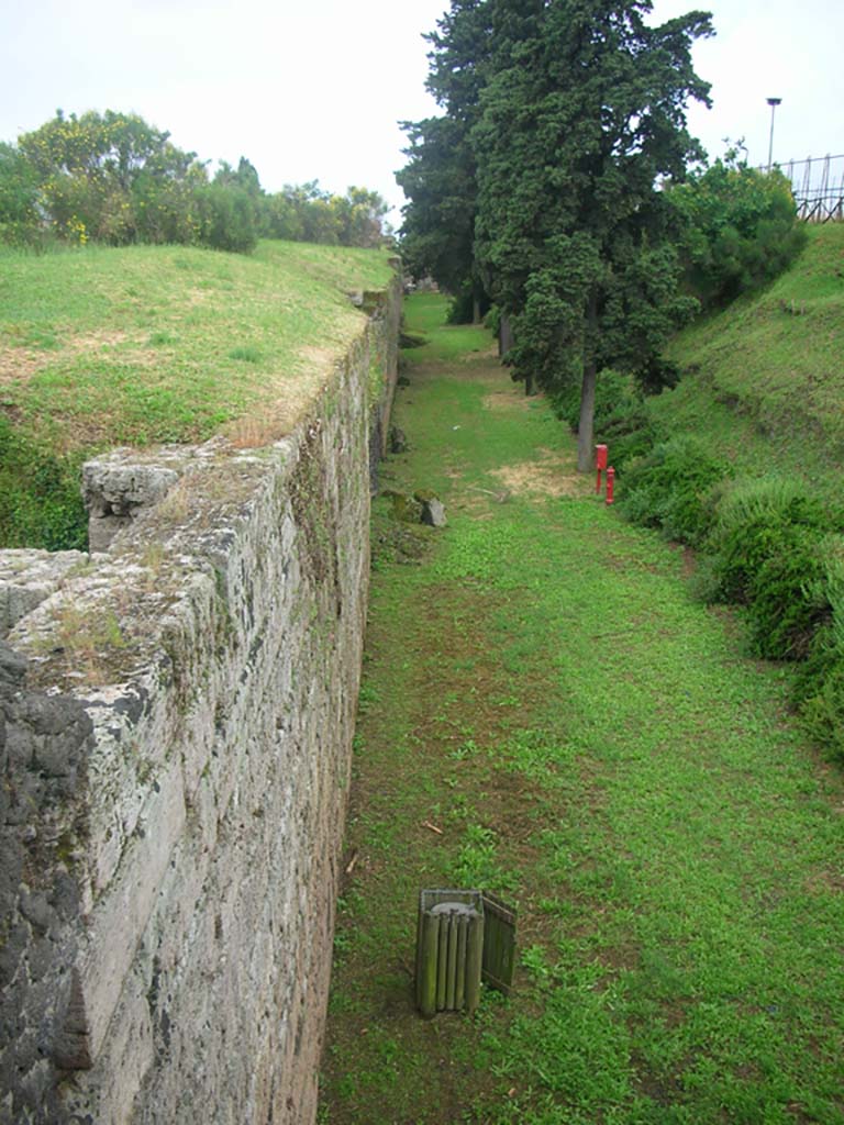 Tower XI, Pompeii. May 2010. 
Looking west from Tower along north exterior city wall. Photo courtesy of Ivo van der Graaff.
According to Van der Graaff –
“A section of wall, roughly 22 metres long and 7 metres high, survives just west of Tower XI. 
It is without doubt the most regular travertine section of the circuit, presenting a well-finished series of blocks, 40-50 centimetres high and 60-80 centimetres wide, stacked in a header-and-stretcher system. Internal piers periodically reinforce the wall, which leans at a slight angle to hold back the earthen mound behind it.”
See Van der Graaff, I. (2018). The Fortifications of Pompeii and Ancient Italy. Routledge, (p.46 and Note 7).
